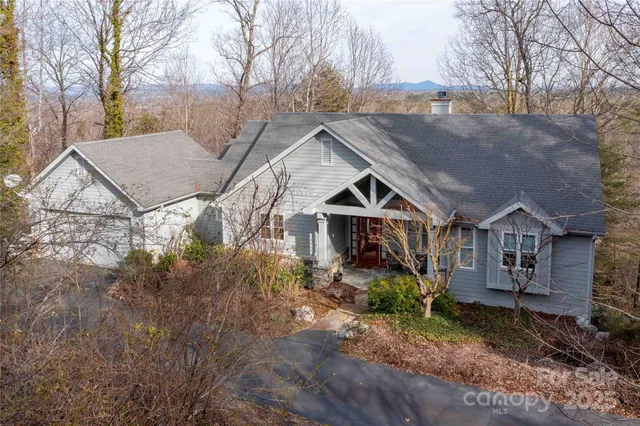 a view of a big house with a big yard and large trees