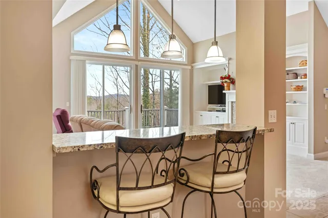 a dining room with furniture and large windows
