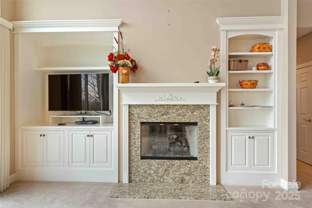 a living room with a fireplace cabinet and a flat screen tv