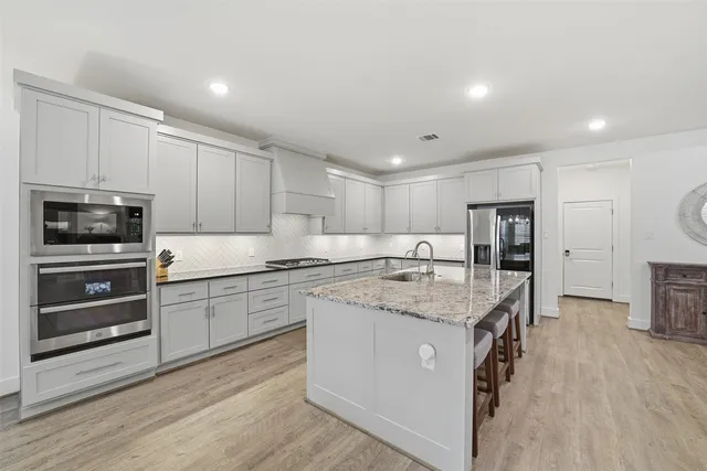 a kitchen with stainless steel appliances granite countertop a stove oven and a refrigerator