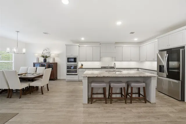 a kitchen with granite countertop kitchen island wooden cabinets and stainless steel appliances