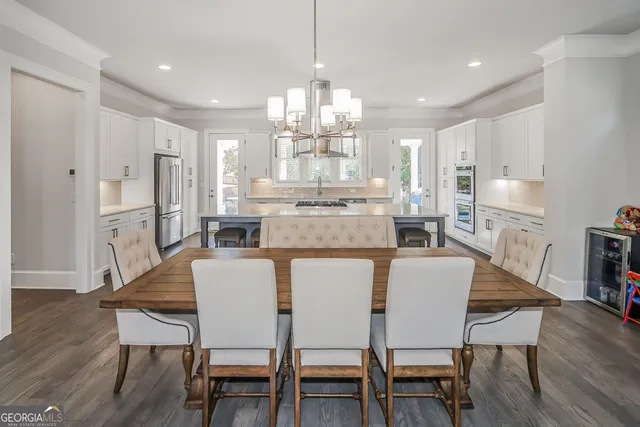 a view of a dining room and kitchen with a table chairs