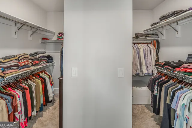a view of walk in closet with clothes and shoes