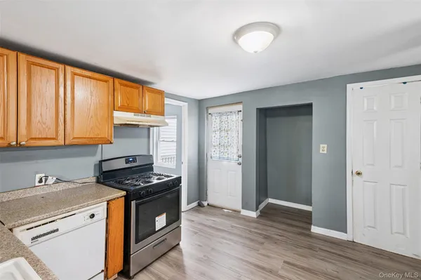 a kitchen with granite countertop a stove cabinets and wooden floor