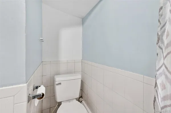 a white toilet sitting next to a shower