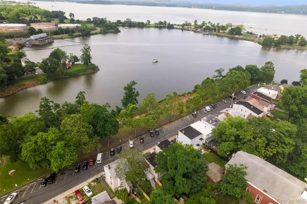 an aerial view of residential houses with outdoor space and lake view
