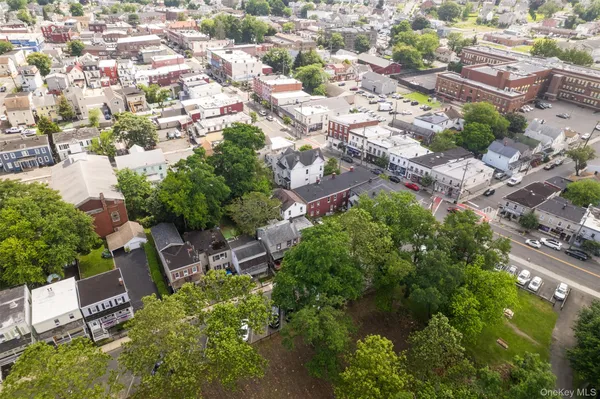 an aerial view of residential house with outdoor space and trees all around