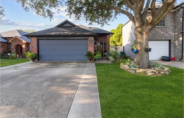 a front view of a house with a garden and yard