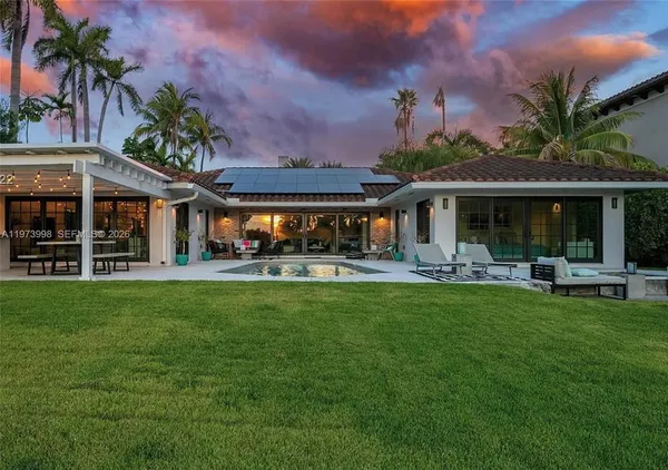 a front view of a house with swimming pool garden and patio