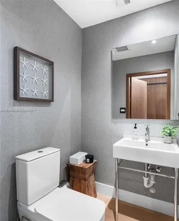 a bathroom with a toilet a sink and mirror