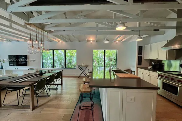 a kitchen with stainless steel appliances a table and chairs in it