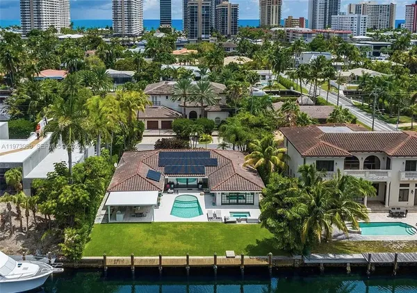 a aerial view of a house with swimming pool a patio and lake view