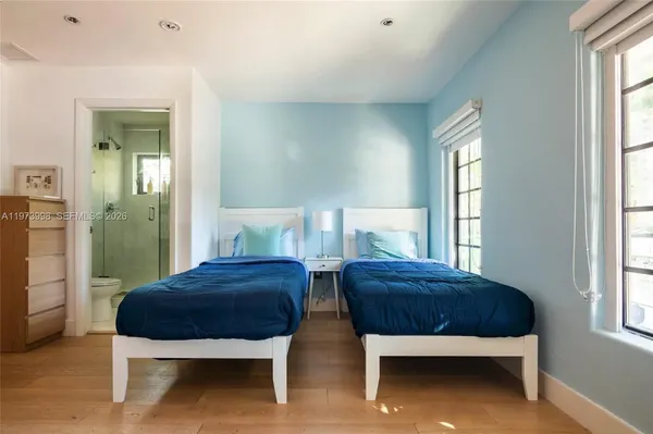 a bedroom with two beds and a window