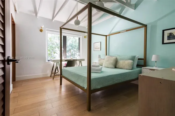 a bedroom with furniture and a large window