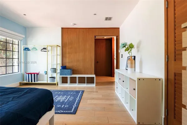 a spacious bedroom with a balcony a bed and a large window