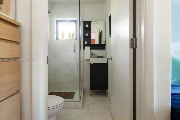 a bathroom with a granite countertop toilet a sink and shower