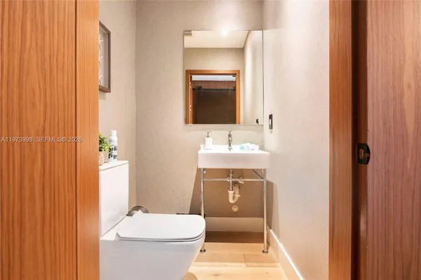 a bathroom with a toilet a sink and mirror