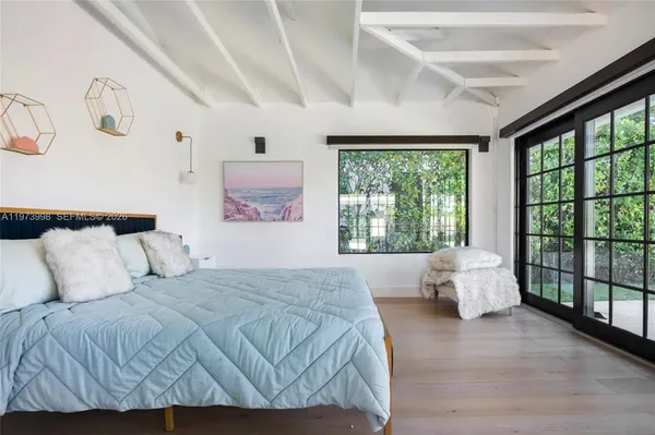 a bedroom with a large bed and wooden floor