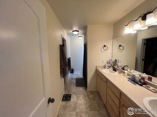 a bathroom with a double vanity sink a mirror and a bathtub