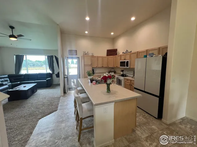 a view of kitchen island with stainless steel appliances granite countertop furniture and a counter top space