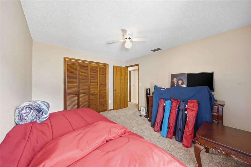 8398 Begonia Street Spring Hill, FL 34608 - Photo 12 of 32 a bedroom with a bed and wooden floor