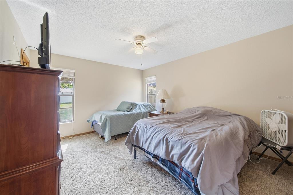 8398 Begonia Street Spring Hill, FL 34608 - Photo 13 of 32 a bedroom with two beds and painting on the wall
