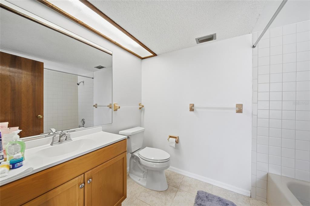 8398 Begonia Street Spring Hill, FL 34608 - Photo 15 of 32 a bathroom with a granite countertop sink a toilet and a mirror
