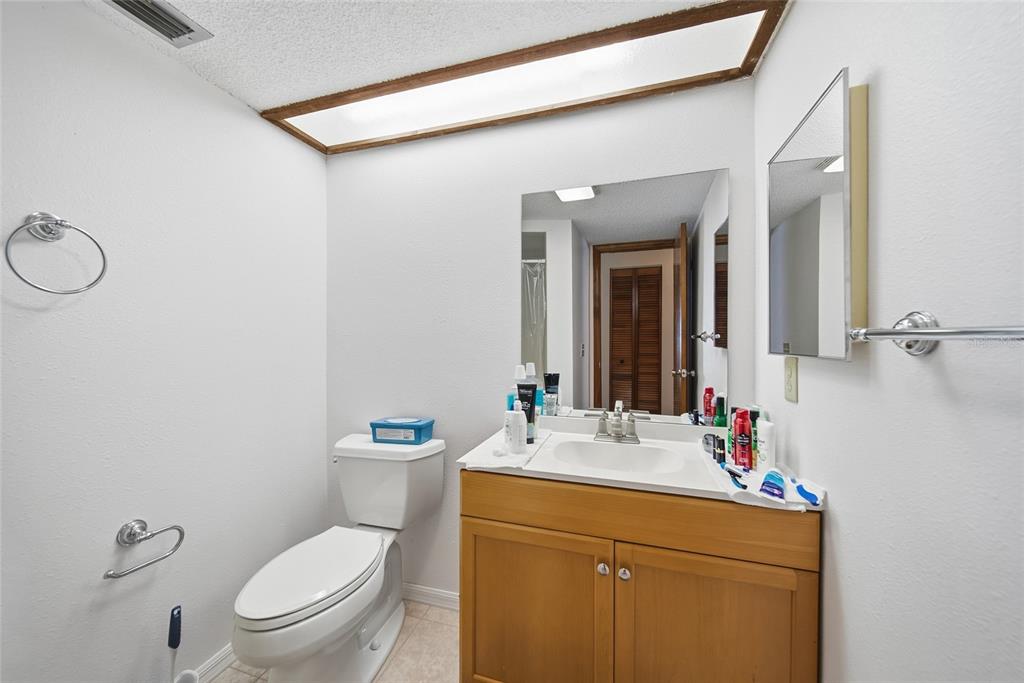 8398 Begonia Street Spring Hill, FL 34608 - Photo 17 of 32 a bathroom with a toilet sink vanity and mirror