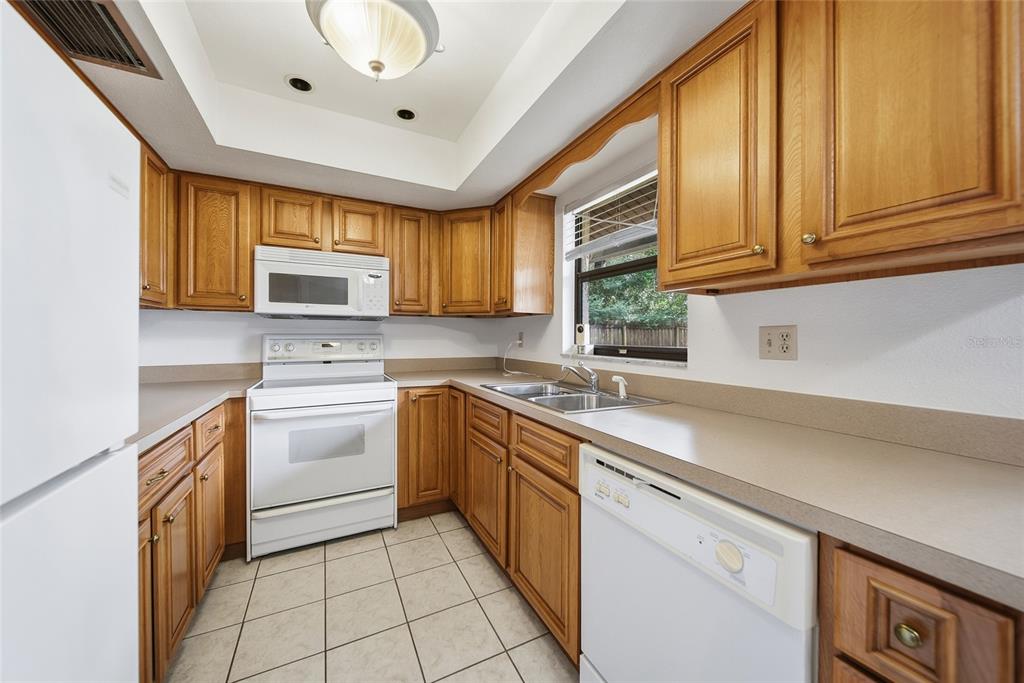 8398 Begonia Street Spring Hill, FL 34608 - Photo 10 of 32 a kitchen with stainless steel appliances granite countertop a sink and dishwasher a stove top oven with wooden floor