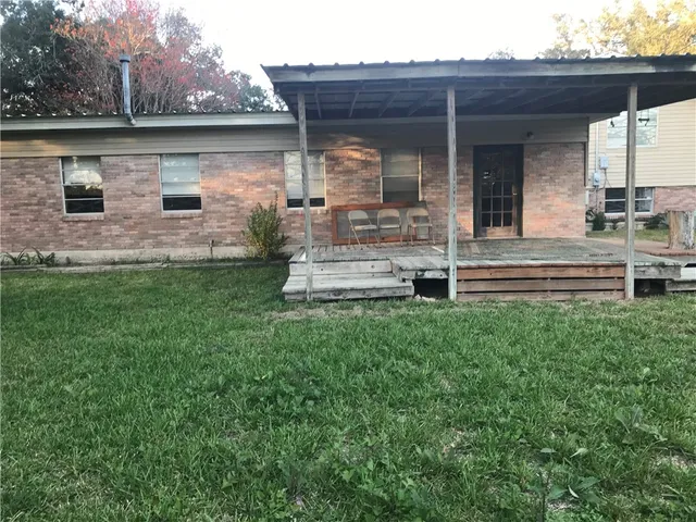 a view of a house with backyard and wooden fence