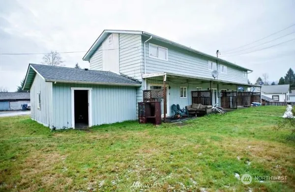 a view of a house with a yard and sitting area