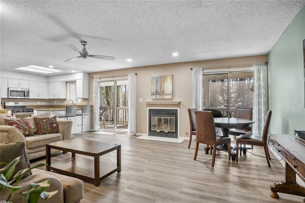 32 Springhedge Ct Street Smyrna, GA 30080 - Photo 3 of 29 a living room with furniture a fireplace and a dining table with kitchen view