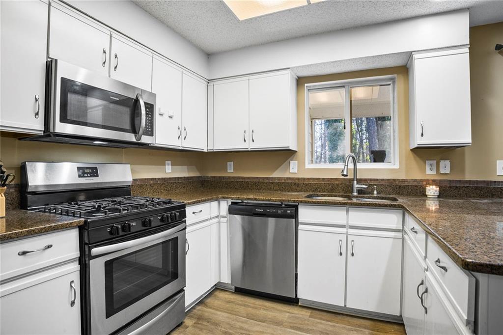 32 Springhedge Ct Street Smyrna, GA 30080 - Photo 7 of 29 a kitchen with stainless steel appliances granite countertop white cabinets granite counter tops and a stove