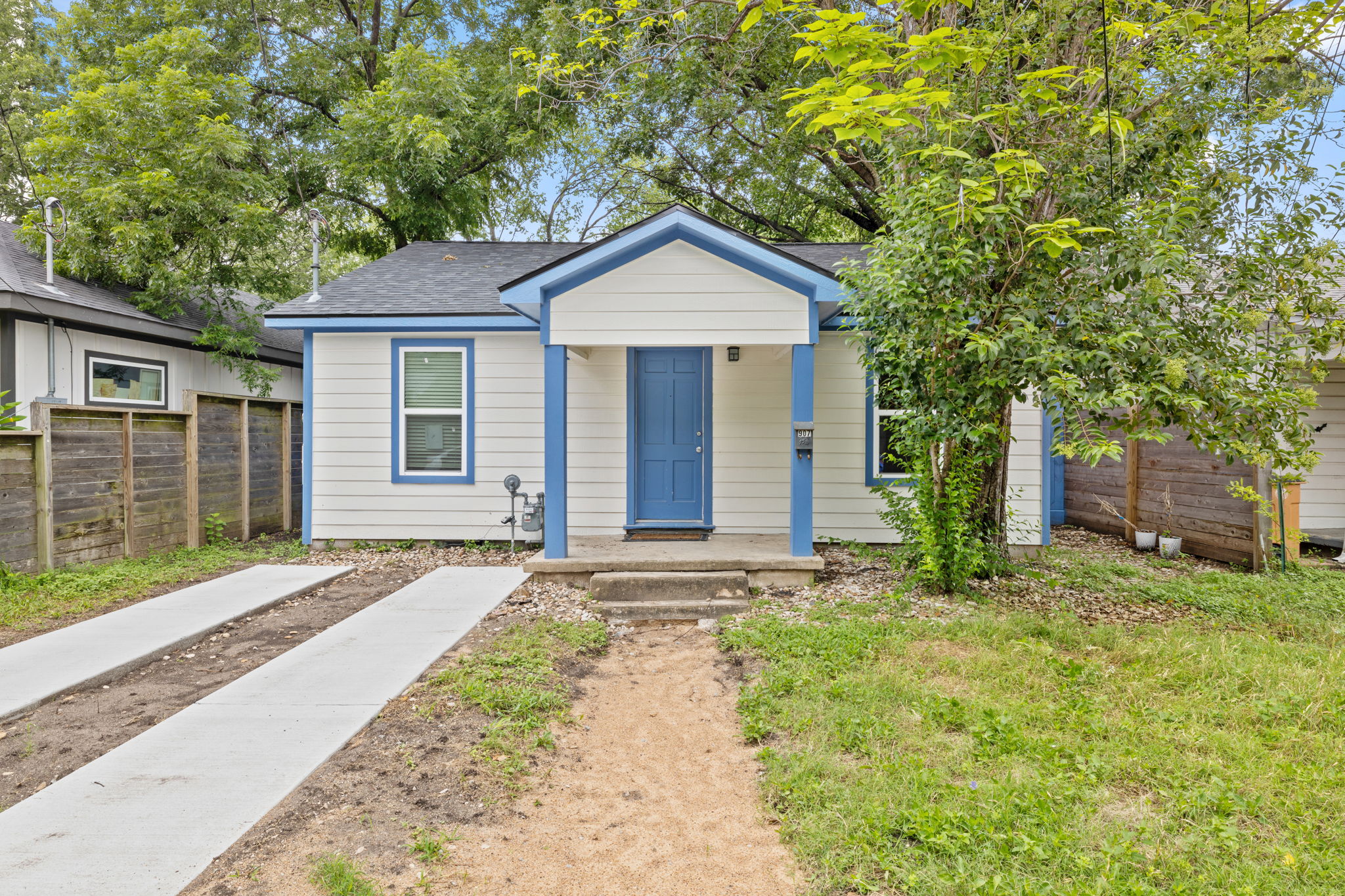 A charming single-story residence with a vibrant blue entrance offers inviting curb appeal.