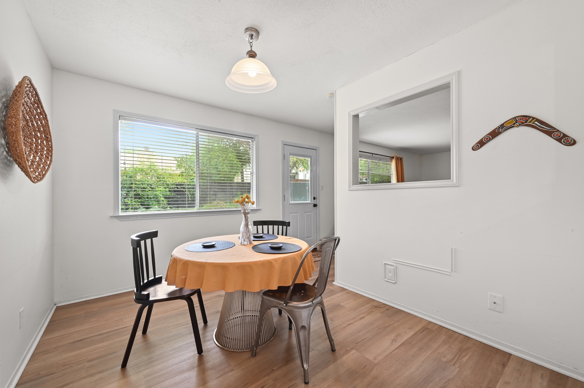 6805 Rearden Road Austin, TX 78745 - Photo 7 of 26 A well-lit dining area features durable wood flooring and ample natural light from a broad window.