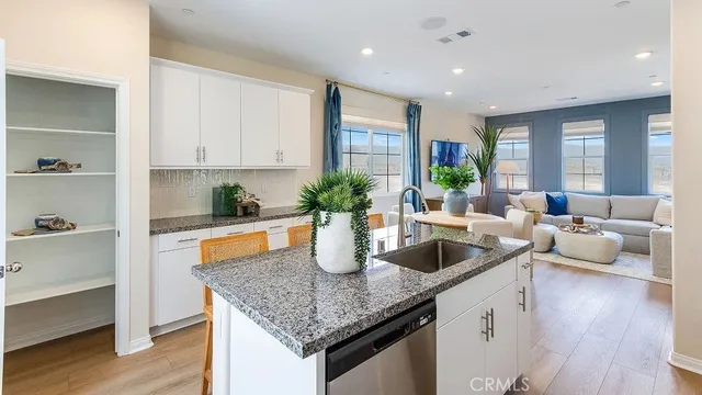 a kitchen with granite countertop a sink a counter top space and living room