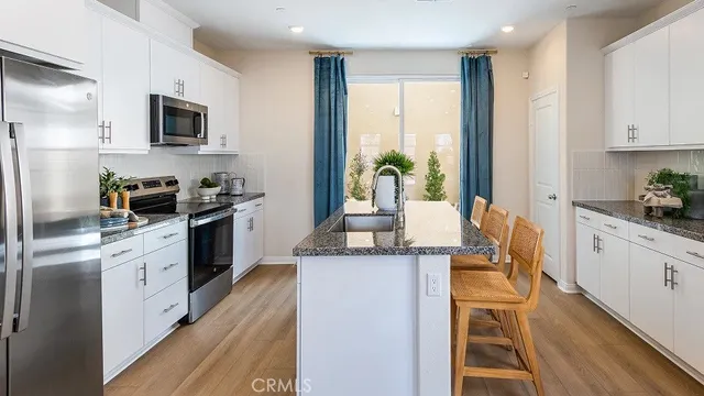 a kitchen with stainless steel appliances granite countertop a stove a sink and a refrigerator