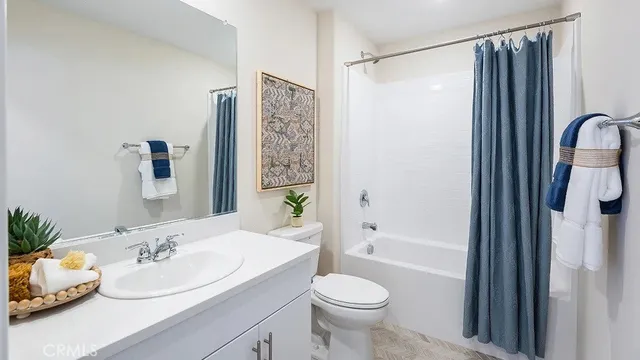 a bathroom with a sink a toilet and shower curtain