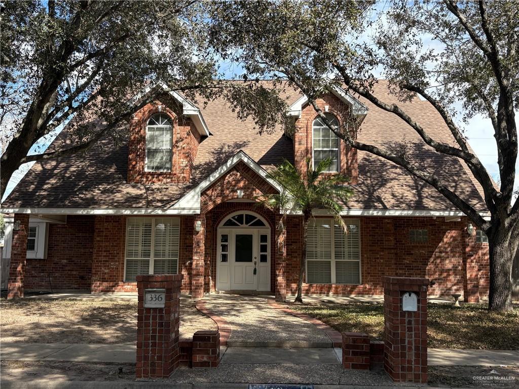 a view of house with a tree and wooden fence