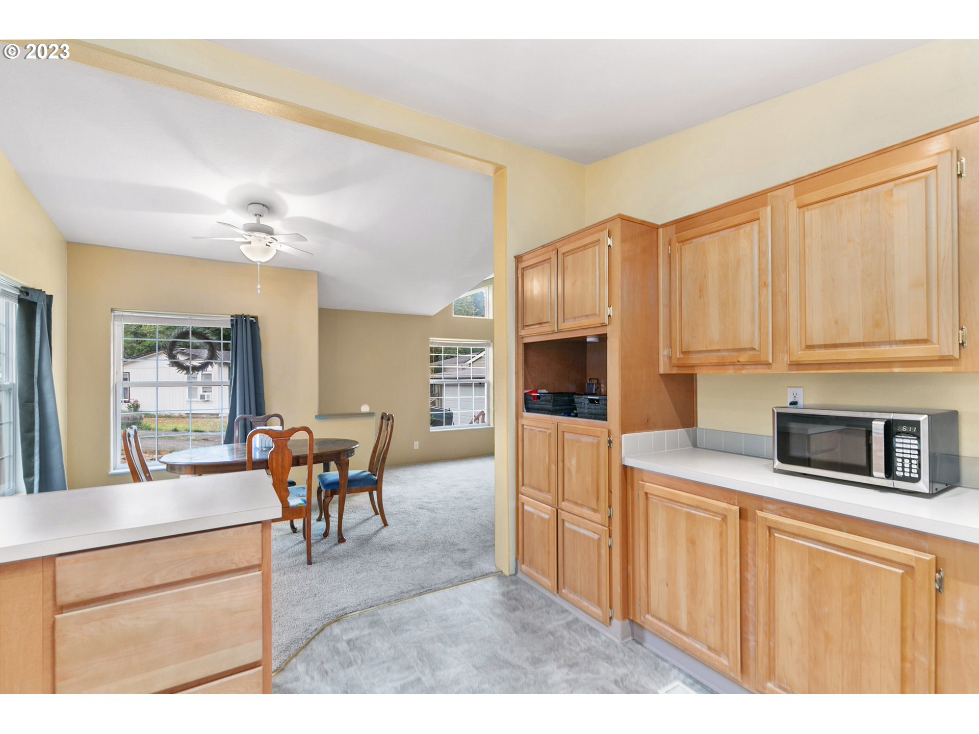 18 South Gee Creek Loop Ridgefield, WA 98642 - Photo 7 of 24 a kitchen with stainless steel appliances kitchen island granite countertop a refrigerator a stove top oven a dining table and chairs with wooden floor