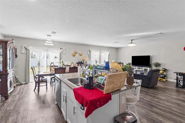a living room with furniture a flat screen tv and kitchen view