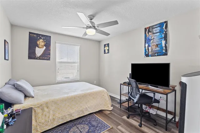 a bedroom with a bed and a ceiling fan