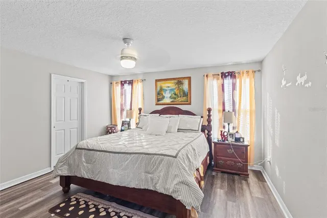 a bedroom with a bed and a flat tv screen on wall
