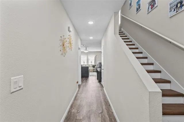 a view of a hallway with wooden floor and staircase