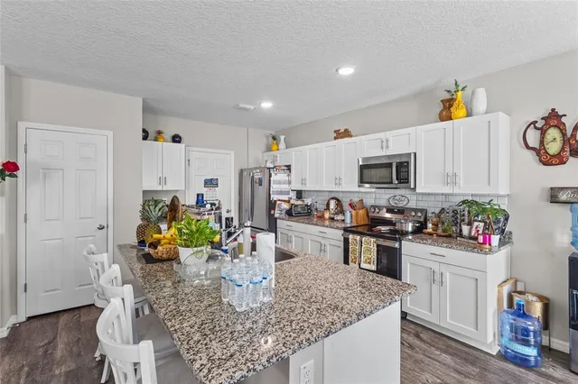 a kitchen with stainless steel appliances granite countertop a refrigerator a stove top oven a sink and dishwasher