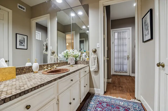 a spacious bathroom with a granite countertop sink and a mirror