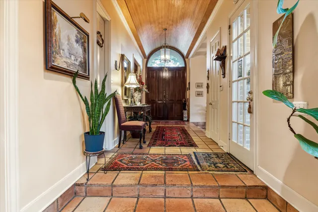 a view of a hallway with wooden floor and a potted plant