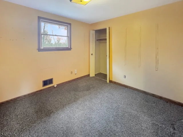 an empty room with windows and closet