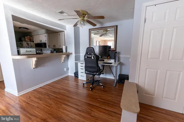 a view of a workspace with furniture and wooden floor