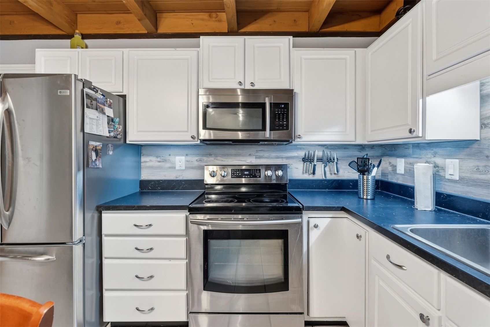 8100 Ryan Gulch Road, Unit 106 Wildernest, CO 80498 - Photo 4 of 43 a kitchen with granite countertop white cabinets and stainless steel appliances